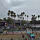 Ohana Festival main stage at Doheny State Beach under storm-gray skies, Amos Lee on the screens, rain ponchos in the crowd, 2023