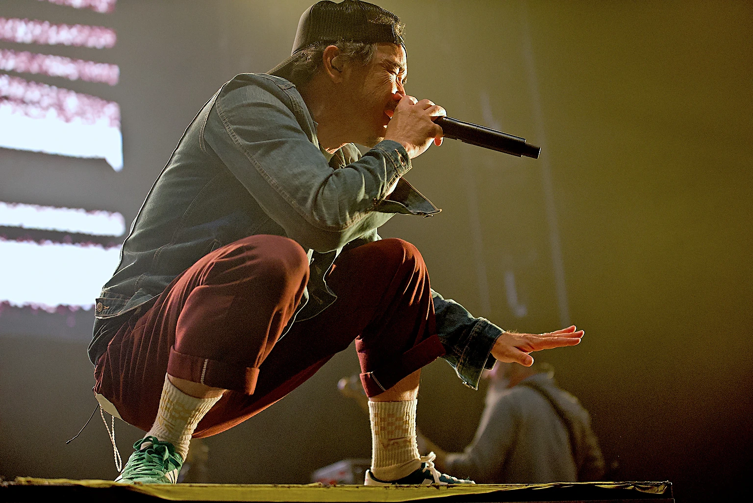 Hoobastank vocalist Doug Robb crouched low at the edge of the stage singing into the microphone at Toyota Arena, Ontario