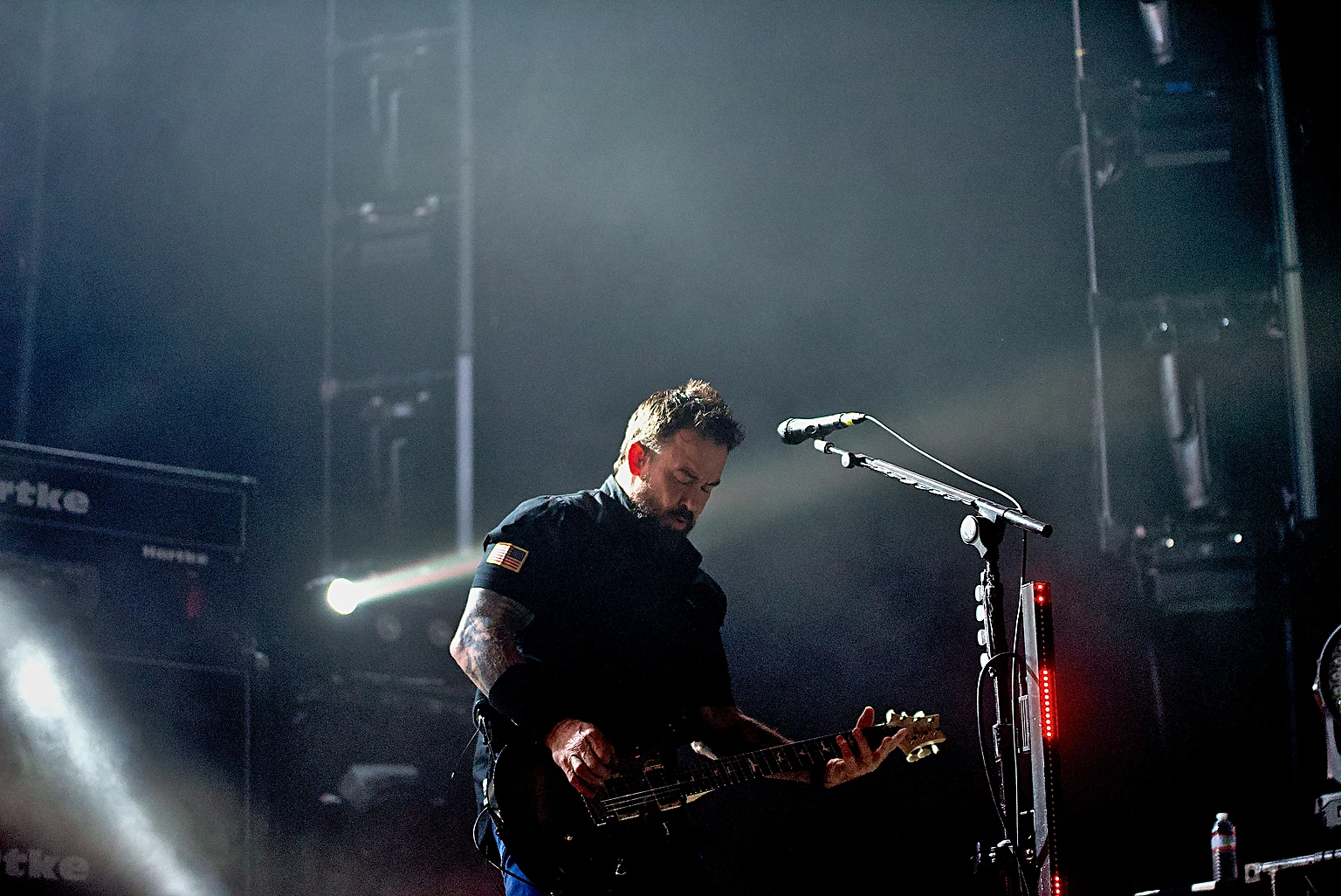 Seether vocalist Shaun Morgan at the microphone between stage light beams at Toyota Arena, Ontario
