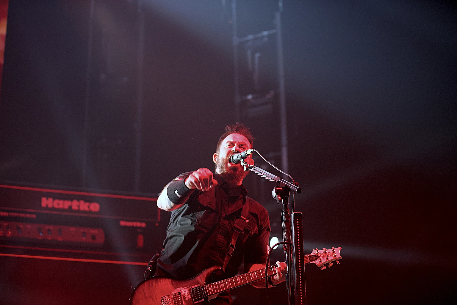 Seether vocalist Shaun Morgan shouting into the microphone under red light at Toyota Arena, Ontario