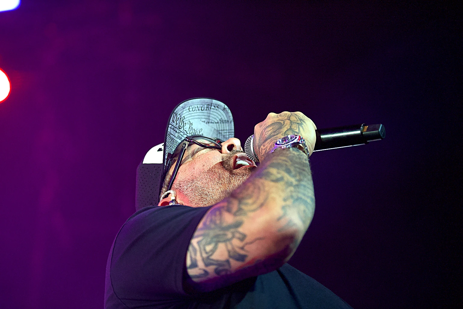 Staind vocalist Aaron Lewis singing at full voice into the microphone at Toyota Arena, Ontario